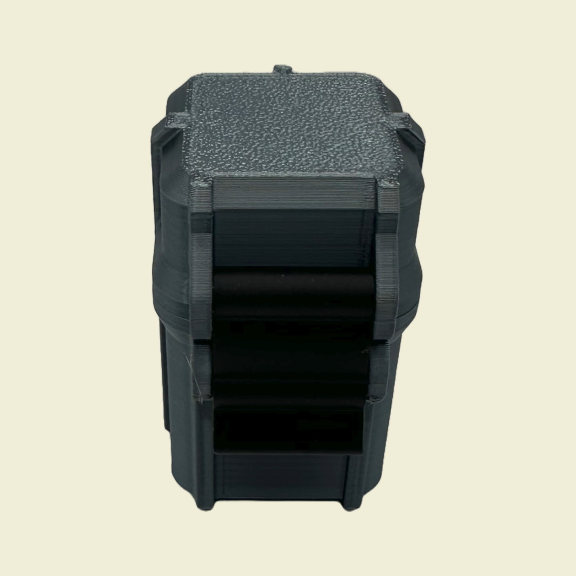 Top-down view of a closed black 3D-printed storage case with latch detail and textured lid. Holds four 3ml vials measuring 12mm x 64mm.