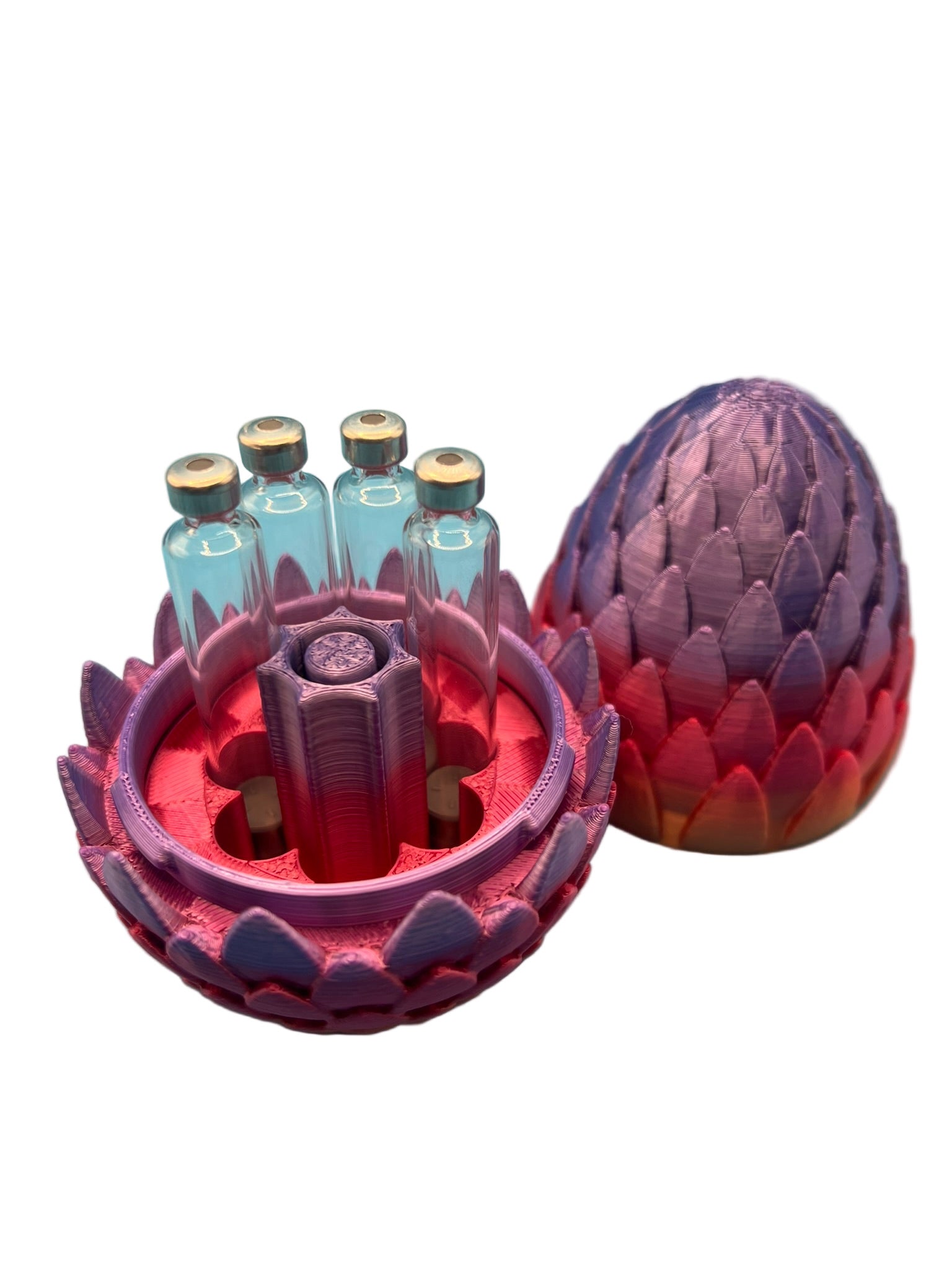 Open dragon egg-style cartridge holder in purple and pink, showing four 3ml glass cartridges arranged around a central purge tower, with the matching closed shell in the background.