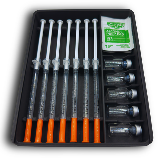 Compact syringe and vial storage case loaded with 7 prefilled 1ml syringes up to 120mm in length, 5 standard 3ml vials, and alcohol prep pads. Slim organizer with protective lid designed for refrigerator storage and wellness supply organization, including TRT, GLP-1, insulin, and peptide routines.