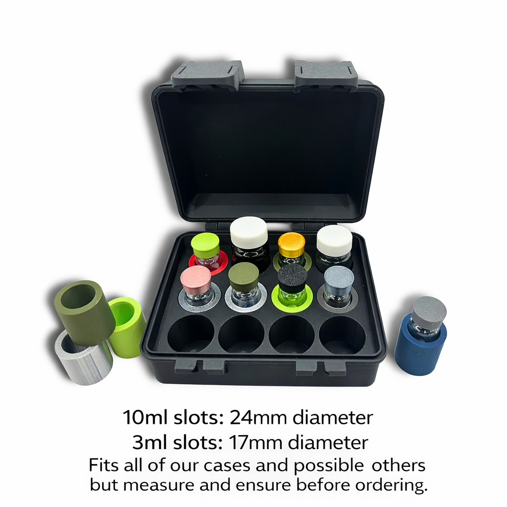 Open black vial storage case with 3mL vial adapters installed in 24mm slots alongside loose adapters in olive, lime green, gray, and navy, holding assorted 3mL glass vials