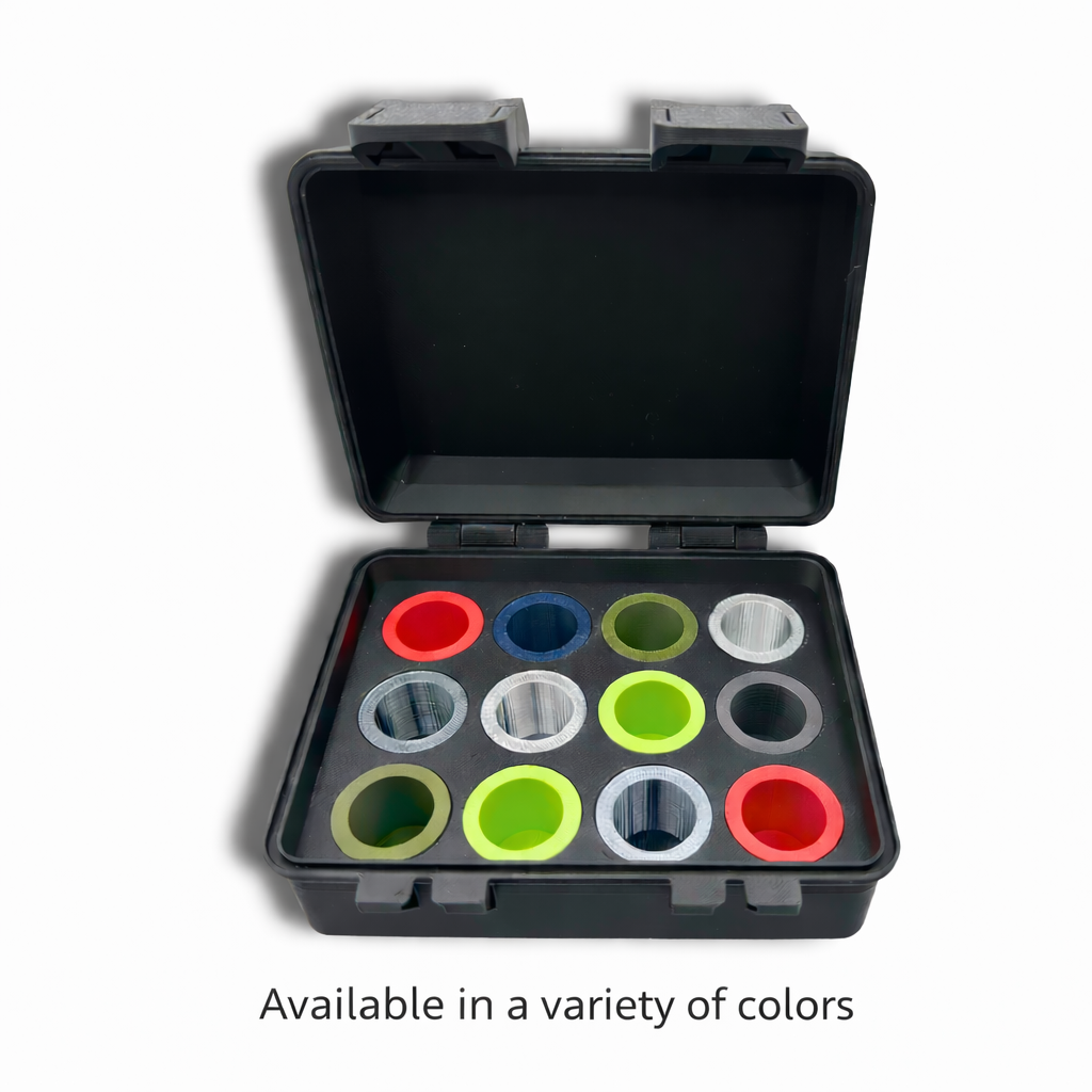Top-down view of open black vial storage case fully loaded with 3mL vial adapters in red, navy, olive, silver, gray, and lime green filling all 12 slots