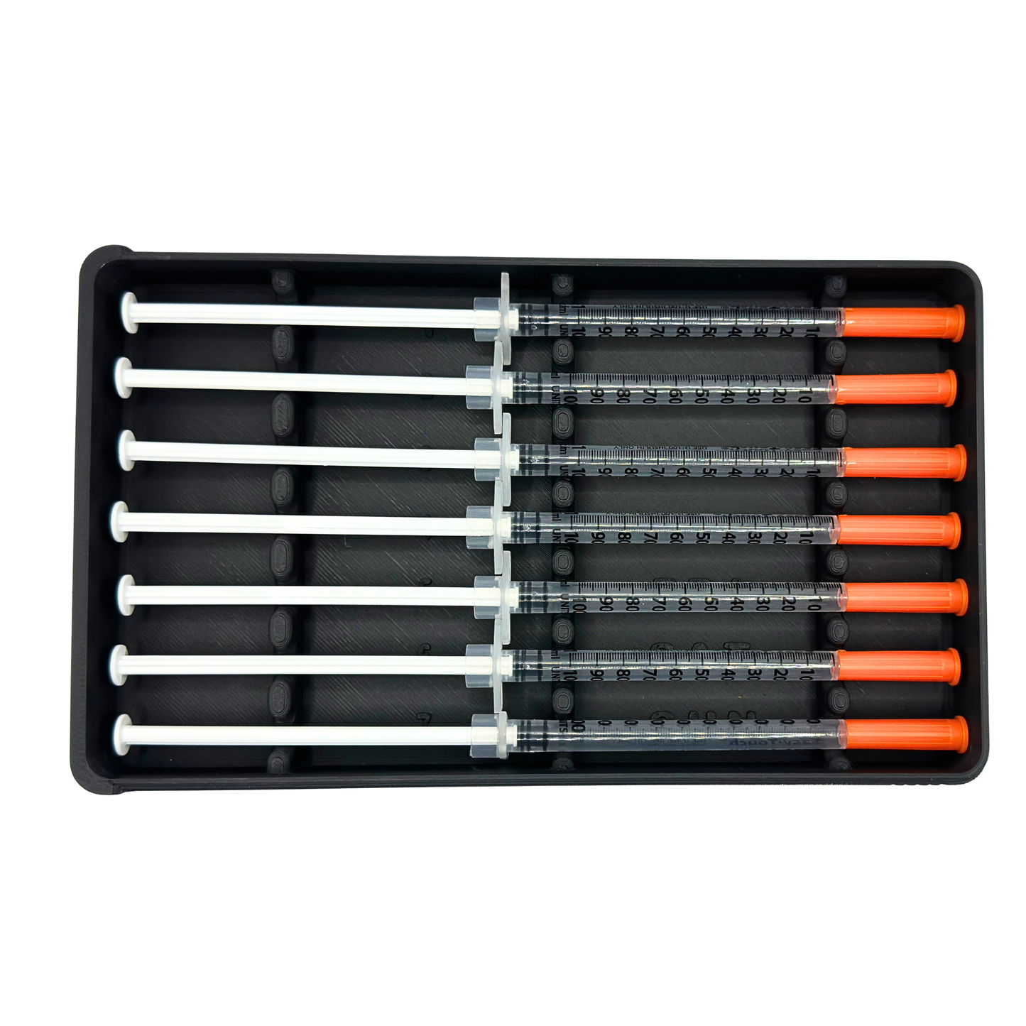 7-slot weekly syringe organizer case shown empty to display interior layout. Numbered slots 1 through 7 with day-of-week labels Monday through Sunday and raised dividers for syringe separation. Black prefilled syringe storage case with sliding lid designed for 1ml insulin syringes up to 180mm long. Ideal for TRT, GLP-1, HRT, or peptide routines.