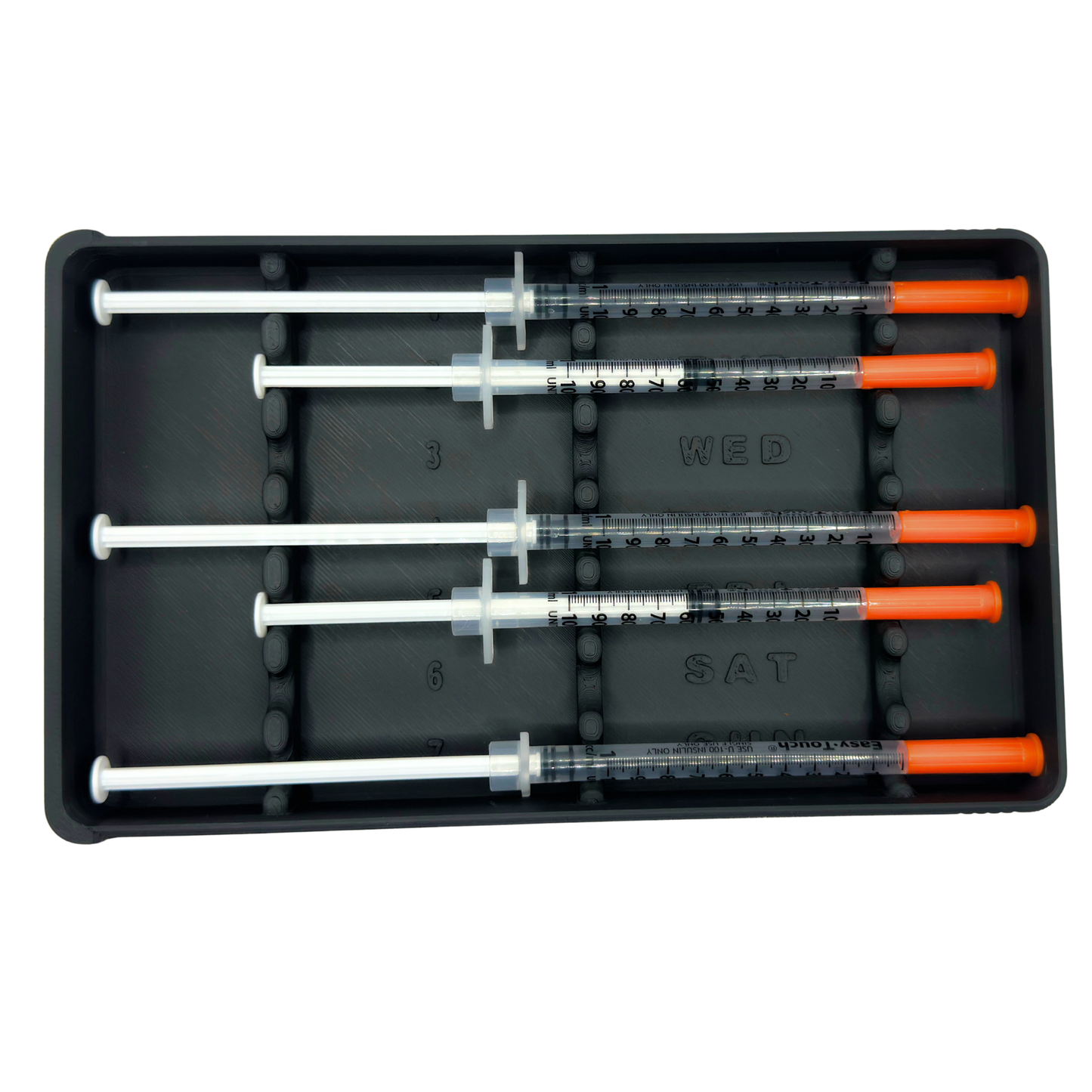 Close-up of 7-slot syringe organizer showing numbered slots and day-of-week labels Wednesday through Sunday with 1ml insulin syringes loaded. Raised dividers keep prefilled syringes separated and secure. Weekly dose organizer case for TRT, GLP-1, insulin, peptide routines. Fits standard 1ml syringes up to 180mm.