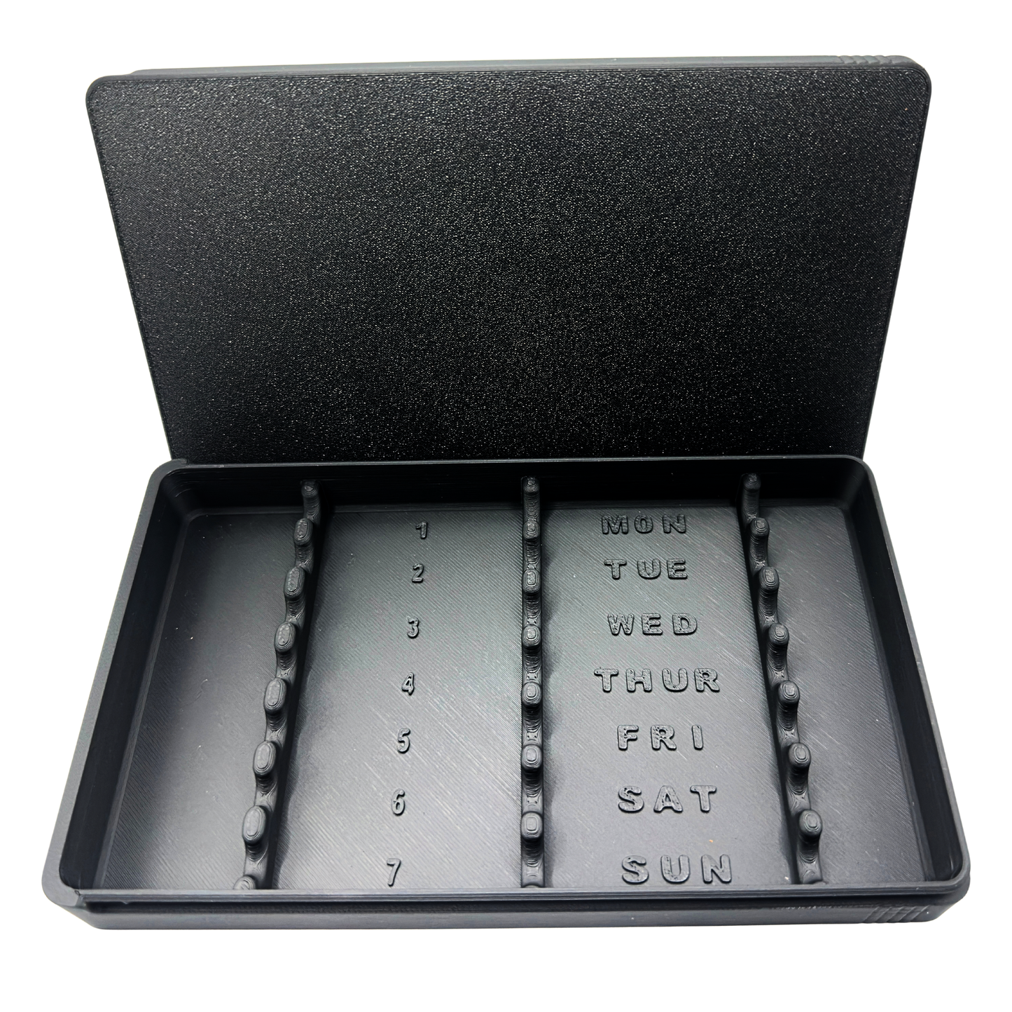 7-slot weekly syringe organizer case shown empty to display interior layout. Numbered slots 1 through 7 with day-of-week labels Monday through Sunday and raised dividers for syringe separation. Black prefilled syringe storage case with sliding lid designed for 1ml insulin syringes up to 180mm long. Ideal for TRT, GLP-1, HRT, or peptide routines.