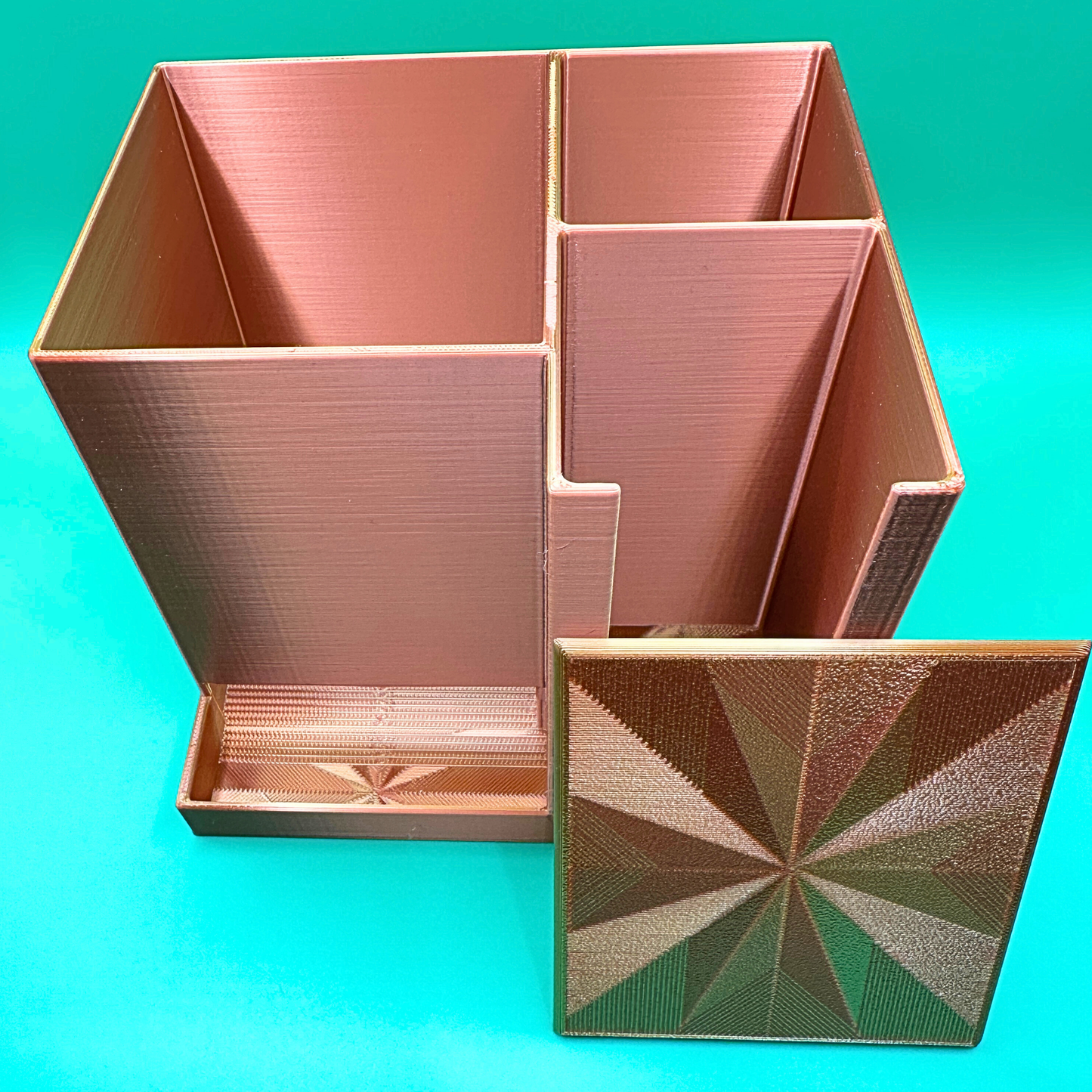 Bronze desktop injection organizer shown empty with the removable lid placed beside the unit, highlighting the open-top design and internal compartment layout. The large left compartment is designed to hold a full box of injection pen needles, while the right side includes a rear compartment for an injection pen or syringes and a front compartment for alcohol prep pads. Designed for organized desktop or countertop storage with clear visibility and easy access.