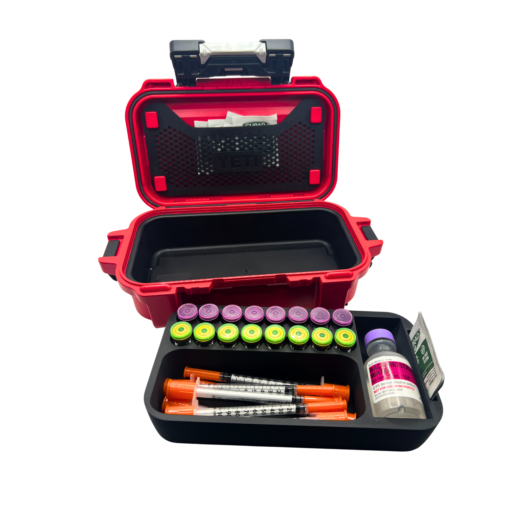 Layered Vault vial organizer insert loaded with 16 vials, syringes, and BAC water shown in front of open empty YETI GoBox 1