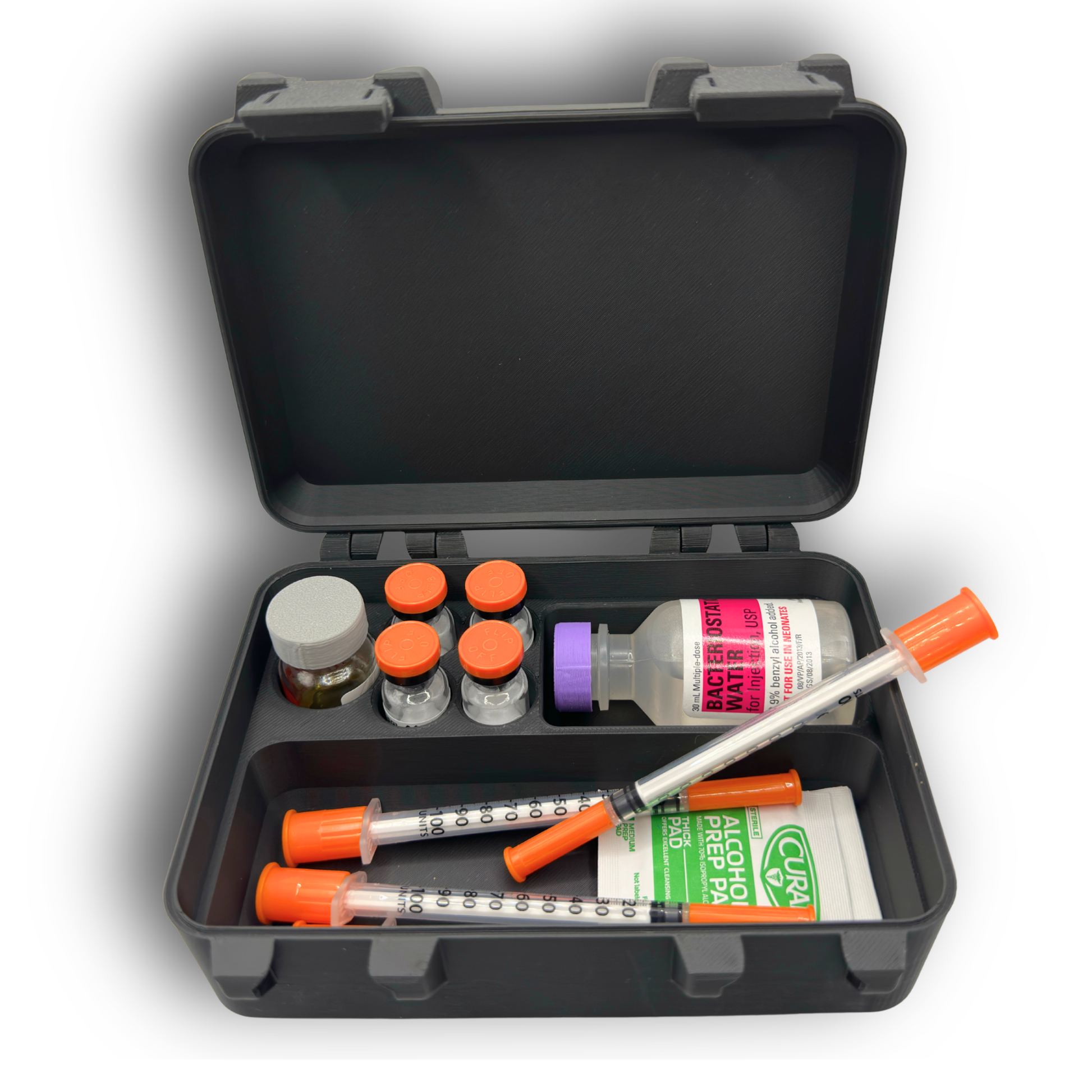 Top view of compact vial and syringe organizer case with lid open. Interior layout shows one 10ml vial slot, four 3ml vial slots, an oversized vial compartment, and an open area for syringes or alcohol prep pads. Items shown for size reference only.
